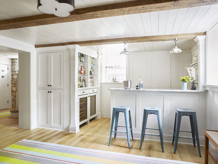 A basement kitchen with a breakfast bar and a painted wood plank ceiling.