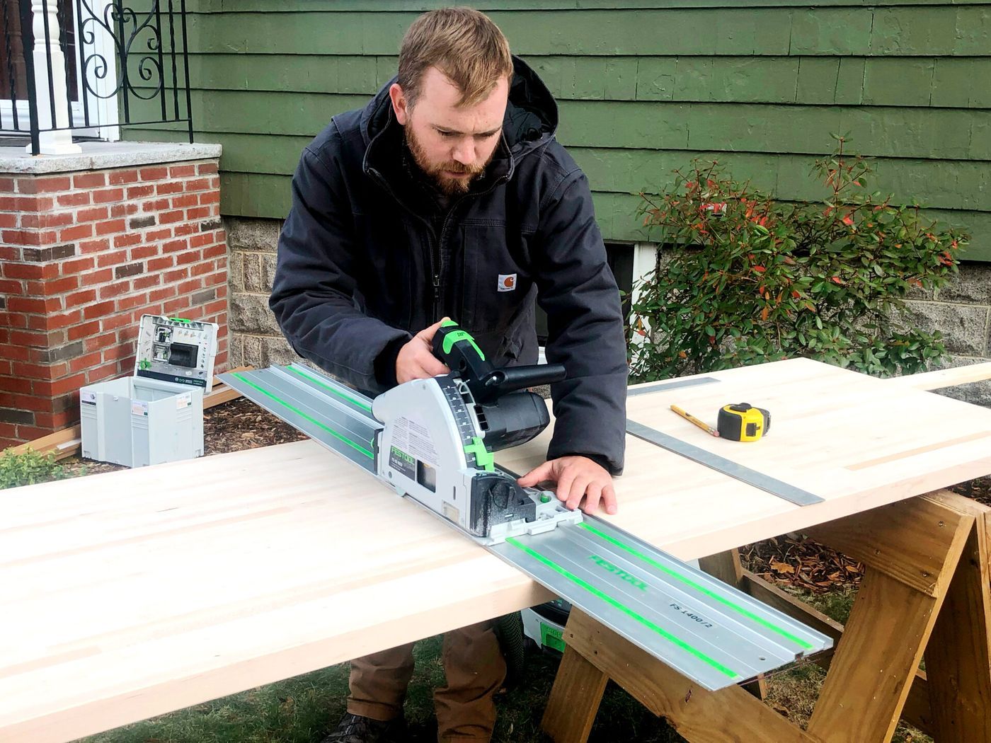 A man constructing butcher block countertop with a cutting tool.