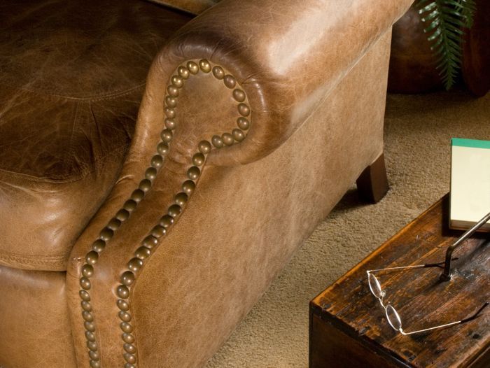 Worn brown leather chair in need of repair.