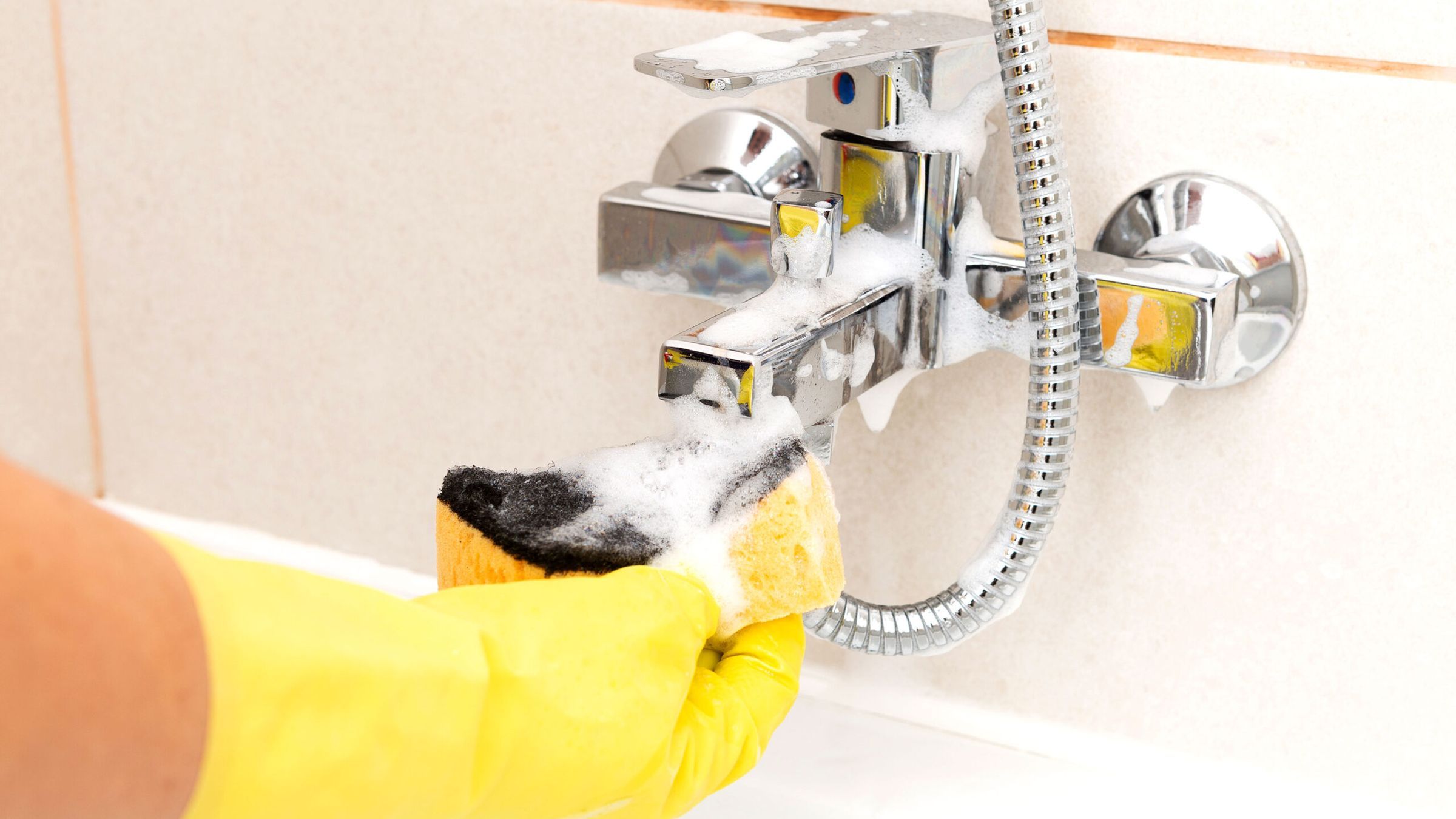 Sponge being used to clean water tap